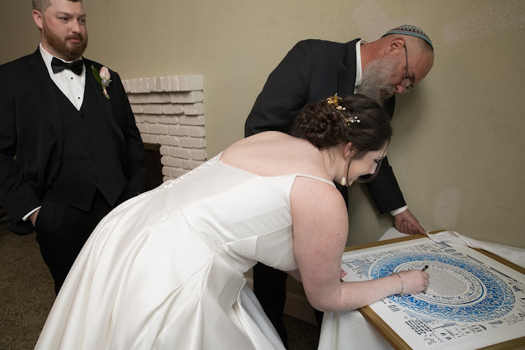 A couple discussing their preferences with a Ketubah artist.